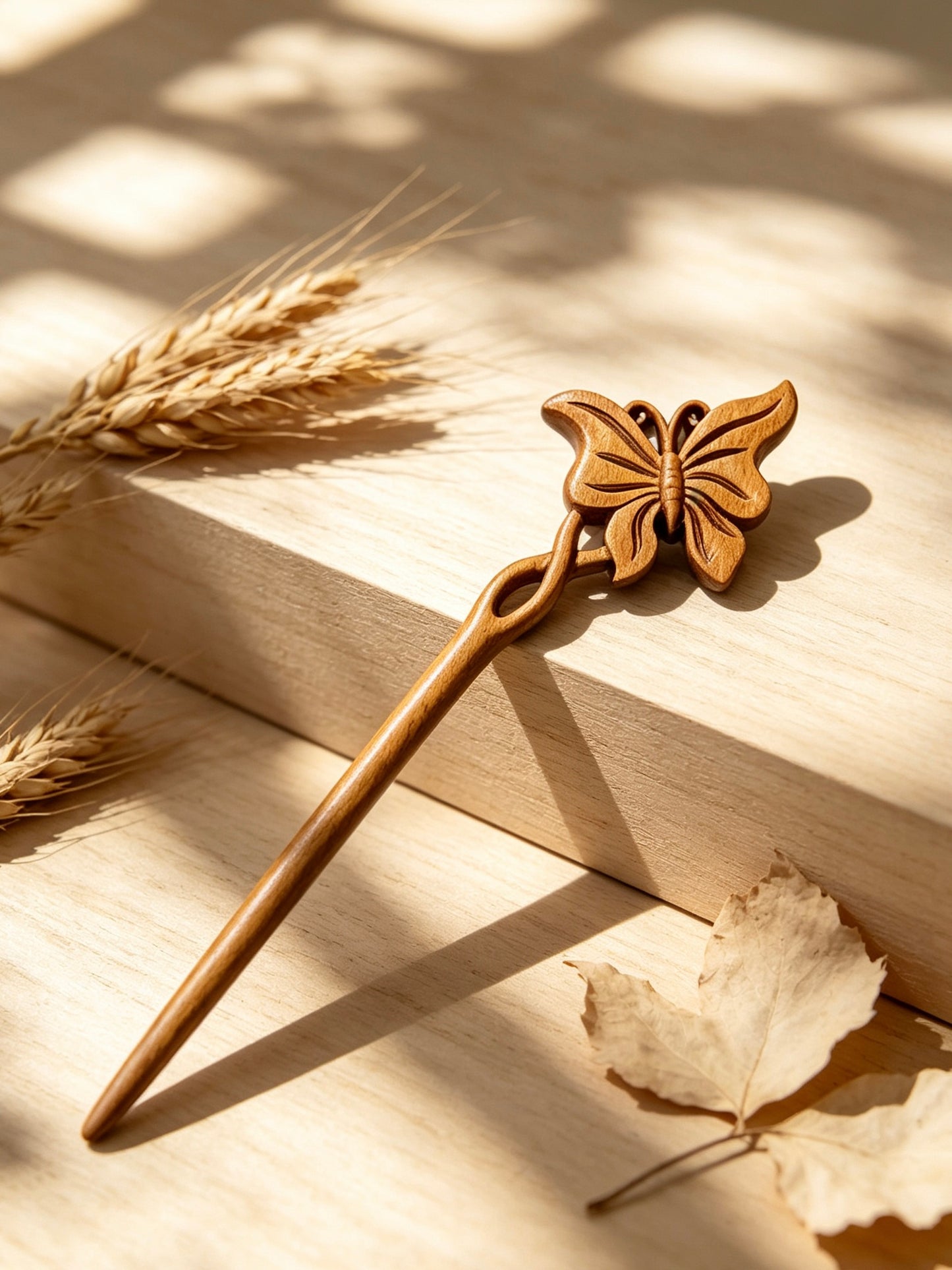Butterfly carved hair stick displayed on a wooden surface