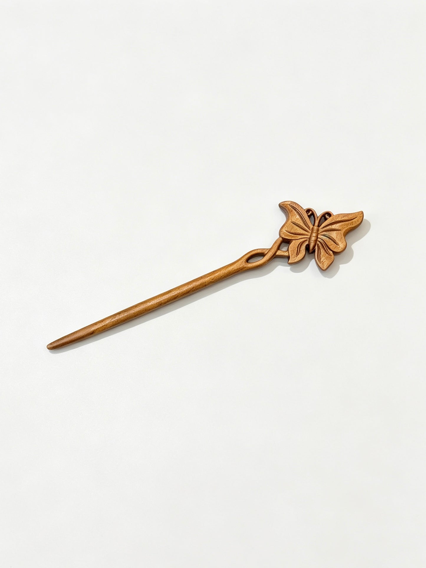 Butterfly carved hair stick displayed on a white background