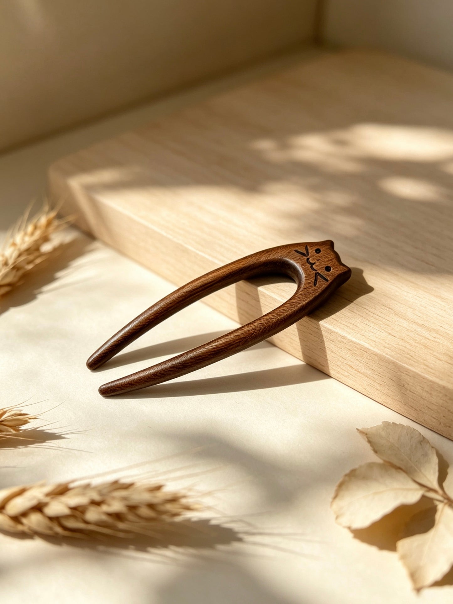 Cat double-prong sandalwood hair fork displayed on a wooden surface