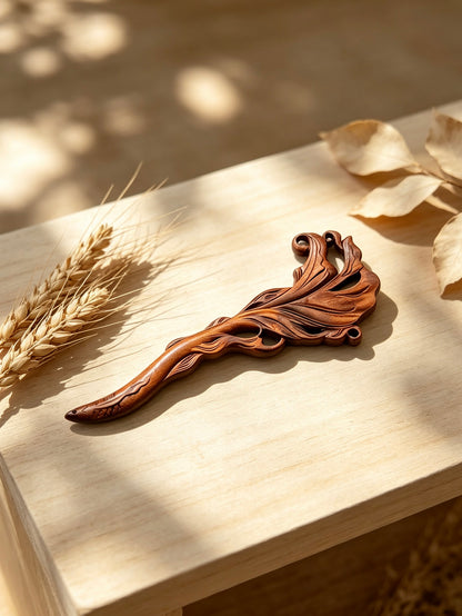 Fish carved sandalwood hair stick displayed on a wooden surface