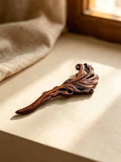 Fish carved sandalwood hair stick displayed on a light fabric surface