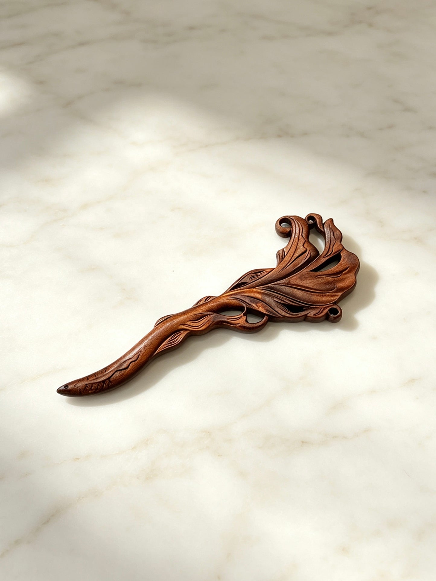 Fish carved sandalwood hair stick displayed on a marble surface