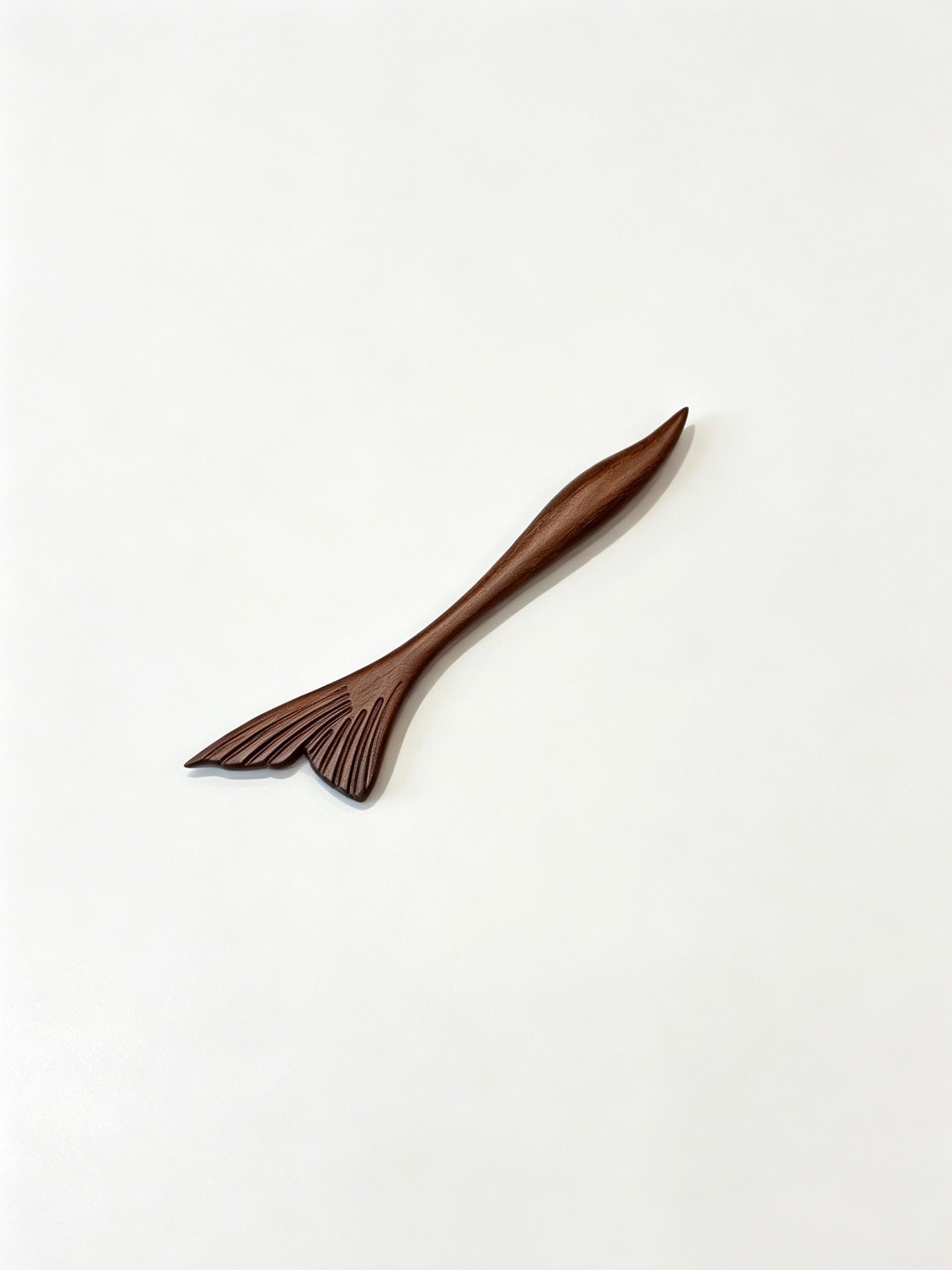 Fish tail sandalwood hair stick displayed on a white background