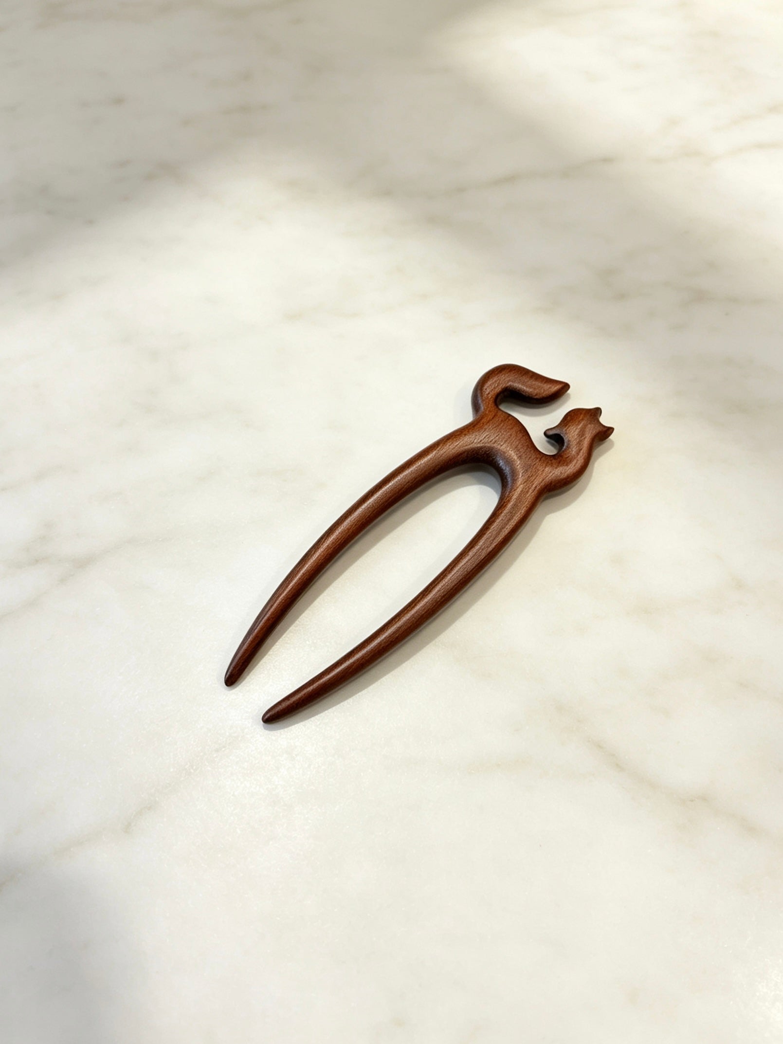 Fox double-prong hair fork displayed on a marble surface