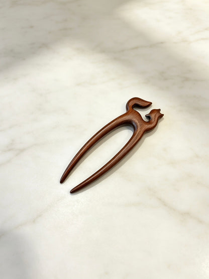Fox double-prong hair fork displayed on a marble surface