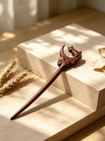 Moon gazing cat sandalwood hair stick displayed on a wooden surface