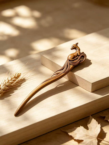 Sandalwood hair stick with a carved deer motif displayed on a wooden surface